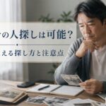 名前だけで人探しをするために、スマートフォンやメモ帳、古い写真を見ながら情報を整理している様子